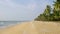 Long empty tropical beach with coconut palms in Kerala, India