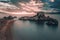 Long exposure against dramatic sunset sky on the beach with dragon rock and calm water