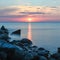 Long Exposure of the Baltic sea landscape. Stones, waves and sunset sun sky. The Gulf of Finland. Summer seascape