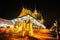 Long exposure a buddhist ceremony where people walk with lighted candles in hand around a temple