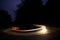 Long exposure of Car driving down a winding road at night, headlights and taillights in blurred motion