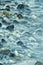 Long exposure. Close up of sea lapping up over glistening rocks.