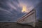 Long exposure clouds solo boat on a beach