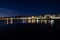 Long exposure of a coastline at night over the sea with city lights