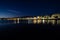 Long exposure of a coastline at night over the sea with city lights