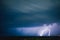 Long exposure of dramatic clouds in the sky and lightning illuminating the area