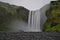 long exposure of famous Skogafoss waterfall in Iceland, green mossy rocks