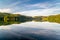 Long exposure at the lake with colorful trees and moving clouds. Soothing landscape photo for backgrounds.