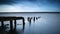 Long exposure landscape of old derelict jetty extending into lake