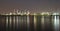 Long exposure night photo crude oil refinery plant and many chimney with petrochemical tanker or cargo ship at coast of the river