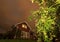 Long exposure night photo of traditional red wooden swedish house and dark heavy clouds with apple tree