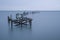 Long exposure of old pier ruin on smooth water