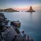 Long exposure panoramic shot of the Cyclope Island with breakwater cube blocks at the coast of Acitrezza, Sicily, Italy