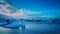 Long exposure photography of floating blue iceberg at Jokulsalon glacial lagoon with bright sun behind the cloud