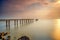 A long Exposure Picture Of abandoned old jetty with cloudy before  burning sunset as background