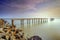 A long Exposure Picture Of abandoned old jetty with cloudy before burning sunset as background