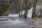 Long exposure of river crossing between wooden trees in the mountains of Madrid