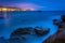 Long exposure of rocks and waves in the Pacific Ocean at twilight, at Monument Point, Heisler Park, Laguna Beach, California.