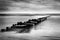 Long exposure shot of the sea and a pier, black and white photo