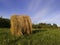 Long exposure shot of single round haystack in the meadow during summer evening, cattle fodder in countryside