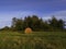 Long exposure shot of single round haystack in the meadow during summer evening, cattle fodder in countryside