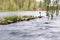 Long exposure shot of a wooden cross by a streaming river