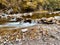 Long exposure of a streaming rocky river in the autumn forest