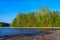 Long Exposure of Sunset at the Paijanne lake. Beautiful scape with stone beach, pine forest and water. Lake Paijanne, Finland