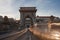 Long exposure in the sunshine. Cars drive fast over the Chain Bridge on the banks of the Danube in Budapest