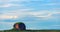 Long Exposure of a Vast Plain with a Towering Rock Formation and Cloudy Sky