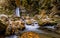 Long exposure view of the beautiful Prunceaâ€“CaÅŸoca Waterfall with fallen leaves in an autumn landscape