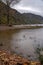 Long exposure view, silky water during autumn in the Wicklow Mountains. Rock on front, Glendalough Upper lake covered with mist an