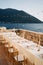 Long festive table stands on the terrace by the sea