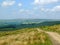 A long footpath running downhill in stoodley moor in yorkshire with fields and farms in the distance with pennine hills