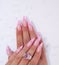 Long French nails with white manicure on a woman`s hand