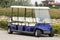 Long golf electric cart parked on parking. Empty shuttle eight seat electro car