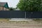 A long gray metal fence and closed gates on the street