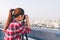 Long hair Asian woman taking cityscape photo on building rooftop in low light situation. Photography or hobby concept. With copy s