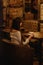 Long-haired beautiful girl in a white sweater sitting in a coffee shop at a wooden table drinking coffee, a lonely girl, view from