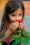 long-haired Colombian girl smells the flowers of the garden in the spring