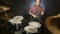 Long-haired drummers play drum kit in a dark room on a black background. Rock musician. Static plan. Wide angle