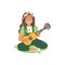 A long haired girl or a young beautiful woman sits on the grass and plays the guitar.