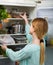 Long-haired woman arranging space in fridge at home