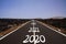 Long hard stony successful way concept: view on endless asphalt road through dry arid volcanic landscape with numbers of years