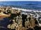 Long-hardened lava, porous, sharp coast of the Mediterranean Sea with oncoming waves against a sky with clouds