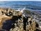 Long-hardened lava, porous, sharp coast of the Mediterranean Sea with oncoming waves against a skys