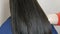 Long, healthy, shiny thick hair of a young woman of dark color