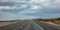 Long highway in the american desert, cloudy blue sky