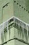 Long icicles on cornice of green brick old house. Danger, risk of injury from falling icicles. Winter concept.