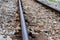 Long iron rusty rail on a background of gray gravel stretching into the distance